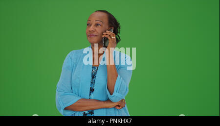 Senior black woman making phone call on green screen Stock Photo