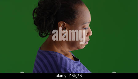 Side profile of sad old black woman on green screen Stock Photo