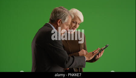 Business team going over financial data on tablet in the hallway on green screen Stock Photo