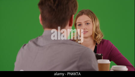 Female employee having conversation with male colleague on green screen Stock Photo