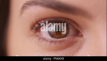 Extreme close up of young woman's eye on green screen Stock Photo