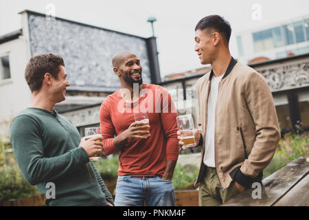 Group of male friends in an outdoor bar Stock Photo