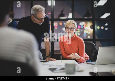 Coworkers working late in an office Stock Photo