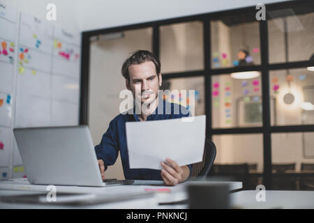 Adult male working late in an office Stock Photo