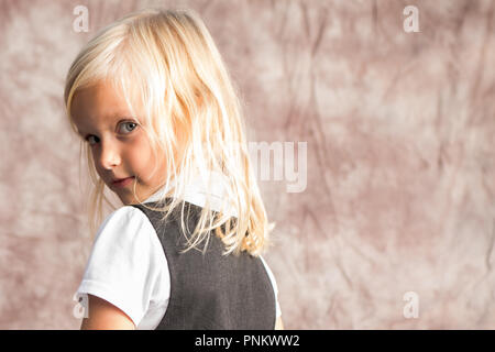 little school girl with blonde hair looking back Stock Photo