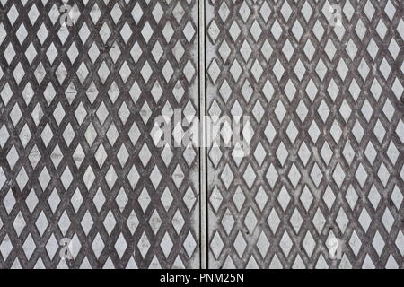 Thick sheet metal with diamond pattern and surface marks suggesting heavy usage. Stock Photo