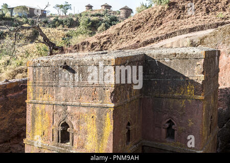 Bet Giyorgis, St George, Ethiopia, Lalibela, Southern Church, with originnal type Ethiopian buildings in background Stock Photo