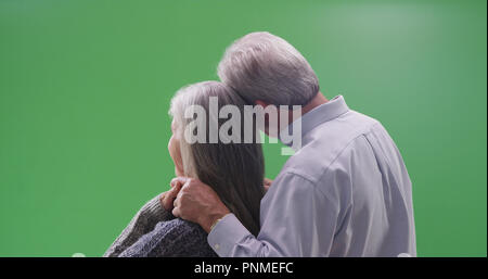 Rear view of loving mature couple looking at a green screen Stock Photo