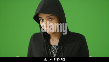 Young Latina wearing hoodie looking at camera on green screen Stock Photo