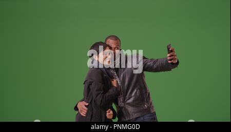 A black couple poses for a picture on green screen Stock Photo