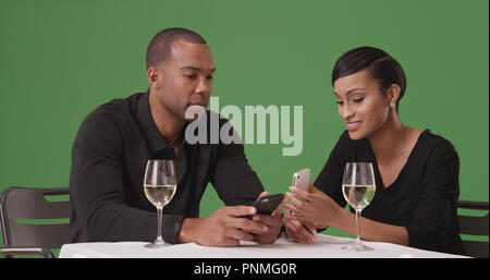 African American couple using mobile phones while out on date on green screen Stock Photo
