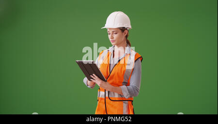 Young woman construction manager using tablet device on green screen Stock Photo