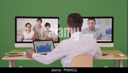 Business man having video conference with group of professionals on green screen Stock Photo