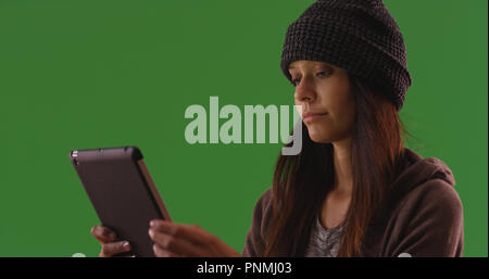 Modern young woman using portable tablet device on green screen Stock Photo