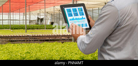 iot smart industry robot 4.0 agriculture concept,industrial agronomist,farmer using tablet to monitor, control the condition in vertical or indoor far Stock Photo