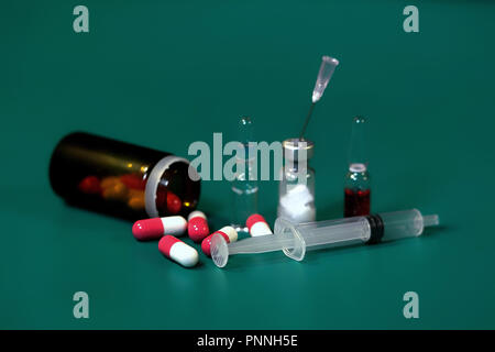 Medication capsules in an opened prescription bottle. Medicine, capsules, tablets, injection, syringe and needle. Close-up of various drugs Stock Photo