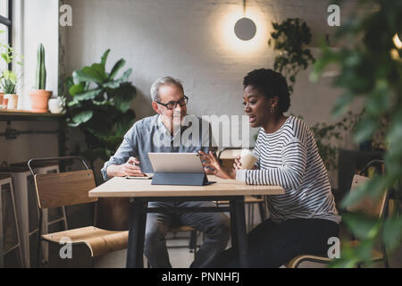 Coworkers having a meeting in a cafe Stock Photo