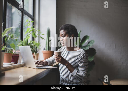 Freelance african american businesswoman working in a cafe Stock Photo