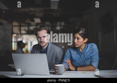 Coworkers working late in the office Stock Photo