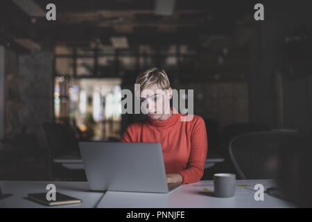 Young adult female working late in an office Stock Photo