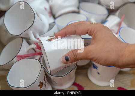 Close up of  women hand picking tea cups in local Indian street market. Stock Photo