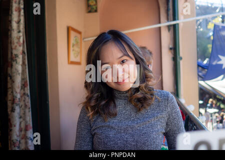 Young woman cheerfully sitting outside on a nice day Stock Photo