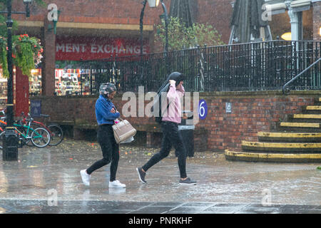 21 September 2018 - Two youths walk through a town centre with a coat over the head for protection during Storm Bronagh Stock Photo