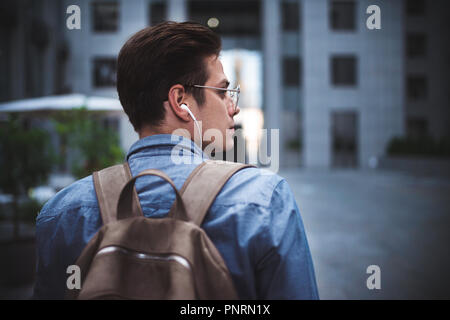 Portrait of handsome successful businessman walking on the street and thinking about startup project. Stock Photo