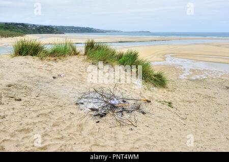 Remains of a small camp fire on a sandy beach,Hayle,Cornwall,England,UK Stock Photo