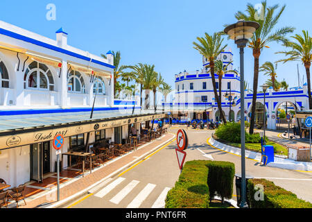 ESTEPONA PORT, SPAIN - MAY 9, 2018: Restaurants and shops in popular tourist town on Costa del Sol coast in southern Spain on sunny summer day. Stock Photo
