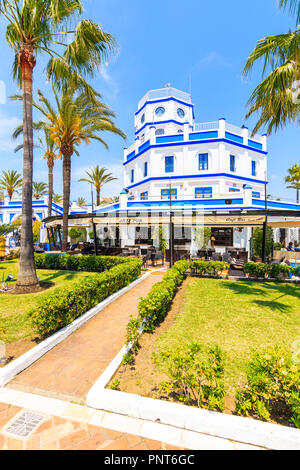 ESTEPONA PORT, SPAIN - MAY 9, 2018: Beautiful lighthouse building and restaurant in Estepona port on Costa del Sol coast in southern Spain on sunny su Stock Photo