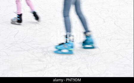 Arty blurry two teenage girl ice skating legs , fun and winter recreation detail Stock Photo