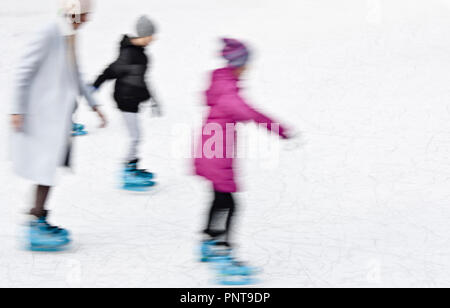 Belgrade, Serbia - January 8, 2018: Mother and children ice skating in motion blur Stock Photo