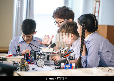 Happy children learn programming using laptops on extracurricular classes Stock Photo