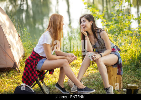 two beautiful female tourists are telling jokes to each other Stock Photo