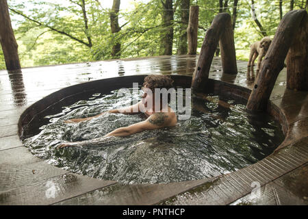 young good looking male is taking a dip in the hot tub Stock Photo