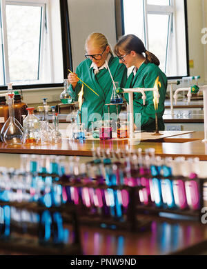 Two teenage girls in school science classroom. Stock Photo