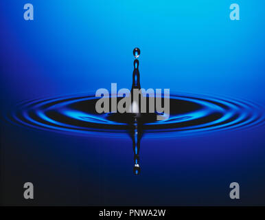 Water droplet splash close up with ripples. Stock Photo
