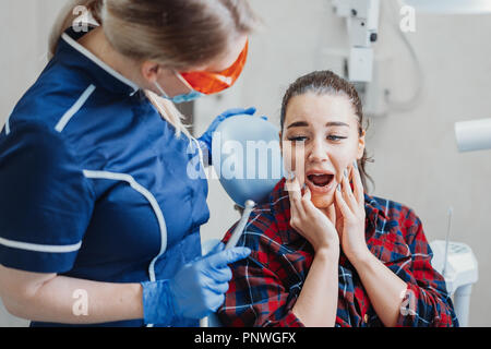 Close up of client frightened by dentist holding dental instruments. Stock Photo