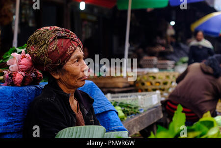 An elderly lady manning a market stall in Bali, Indonesia Stock Photo