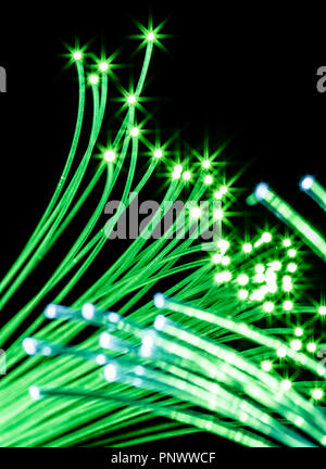 Bundle of optical fibers with green light. Black background. Stock Photo