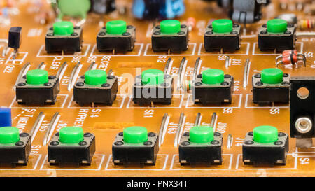 Dismantled VoIP phone keypad. Buttons on circuit board. Green plastic pushbuttons close-up. Electronic components in disassembled telephone keyboard. Stock Photo
