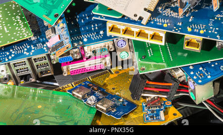 E-waste pile from discarded computer parts. Colorful background from PC components - mainboards, PCB, connectors. Hardware, electronics industry, eco. Stock Photo