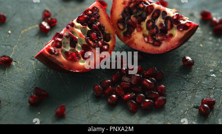 Ripe pomegranate halves on board Stock Photo