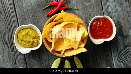 Served nachos with sauces on table Stock Photo