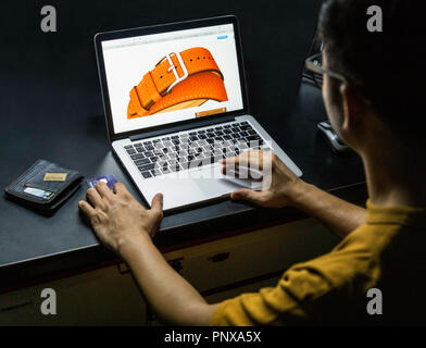 A person's hand holding credit card for online shoping on laptop Stock Photo