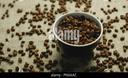 Cup of coffee beans on canvas Stock Photo