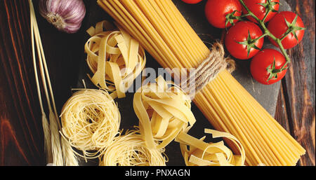 Various pasta and tomatoes with garlic Stock Photo