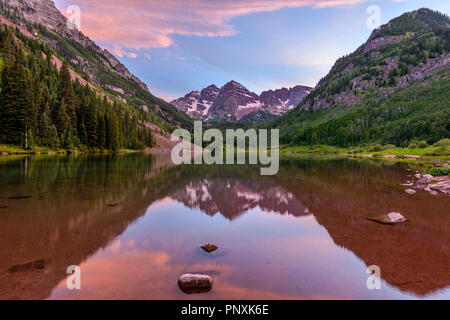 Sunset Maroon Lake - A spring sunset view of purple Maroon Bells reflecting in crystal clear Maroon Lake, Aspen, Colorado, USA.