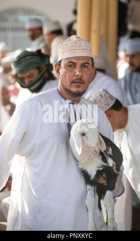 Nizwa, Oman, 21 September 2018: omani men at a market, buying and selling goats at a traditional habta auction Stock Photo